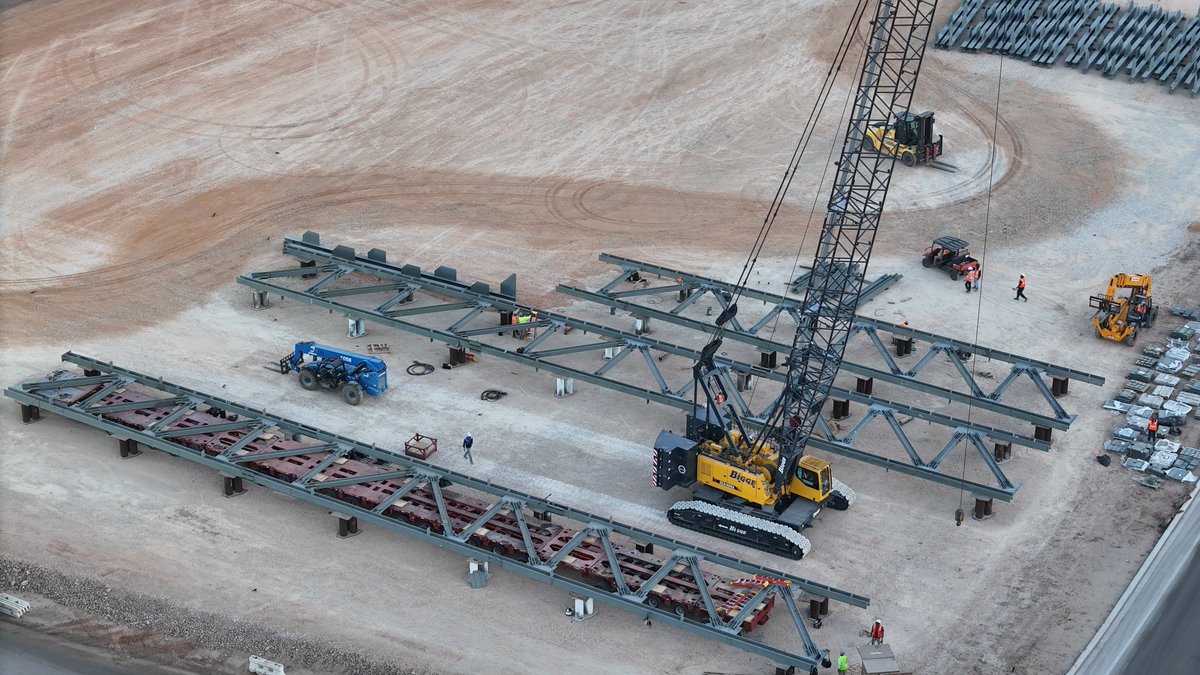 JoeTegtmeyer's tweet photo. On the E side of Giga Texas, the joint @SpaceX & @Tesla Advanced Tech Chip Fab foundation continues to receive huge concrete pours working to the N grade beam, while more footing & Footing support structures are completed on the S end. 

Steel erection on both the E & W sides of the center area is accelerating along with large steel truss structure assembly nearby, possibly to span the width of the foundation. This design ^ assembly is vastly different than any other structure on the site.

Large numbers of steel beams, many with welded on massive joining tabs have been delivered to the site while the nearby new concrete mobile batch plant is in operation to support construction of this $3B Research & Development facility.