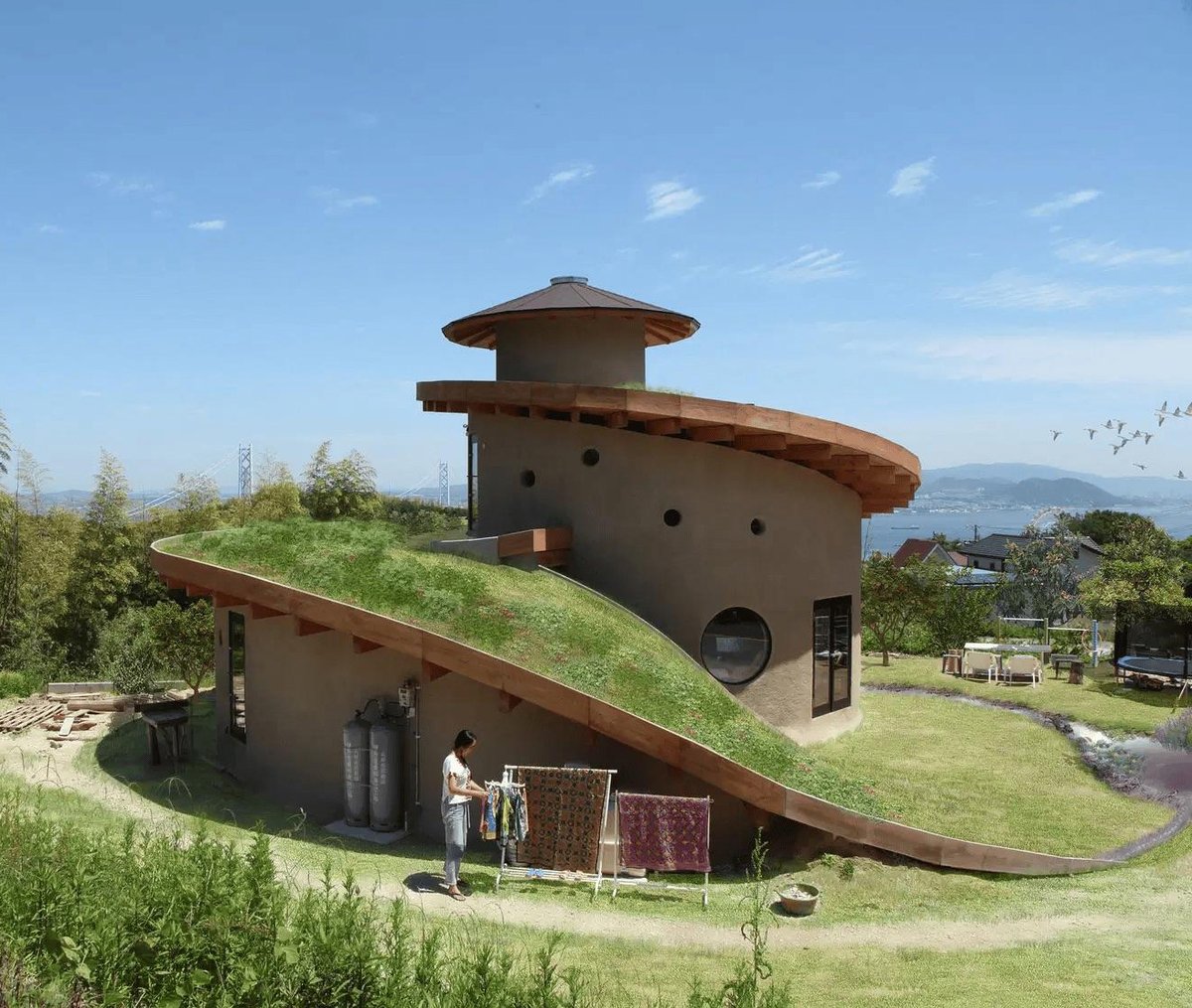 archpng's tweet photo. THIS HOUSE HAS A SPIRAL GARDEN FOR A ROOF.

Completed in 2017 on Japan's Awaji Island, Spiral Garden was designed by Ryuichi Ashizawa Architects & Associates for a family of four.

Its grass-covered roof rises continuously from ground level, spiraling toward the center of the house. The changing height, sunlight, and humidity allow different types of plants to grow.

Rainwater travels down the sloping roof into collection ponds, while the earthen walls and floors help regulate indoor temperatures.

The house was designed to grow and change with the surrounding landscape.

Photography: Kaori Ichikawa.