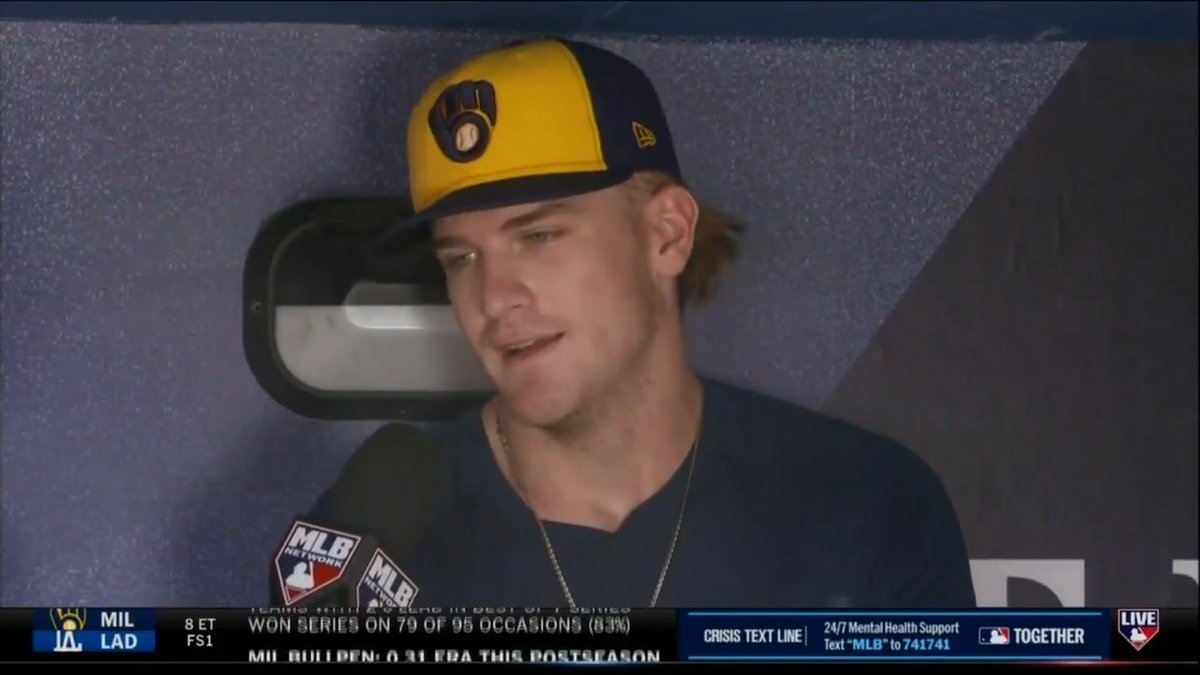 A young baseball player in a Brewers cap is interviewed by MLB Network, with a scorebug showing MIL vs LAD, Game 8 ET FS1.
