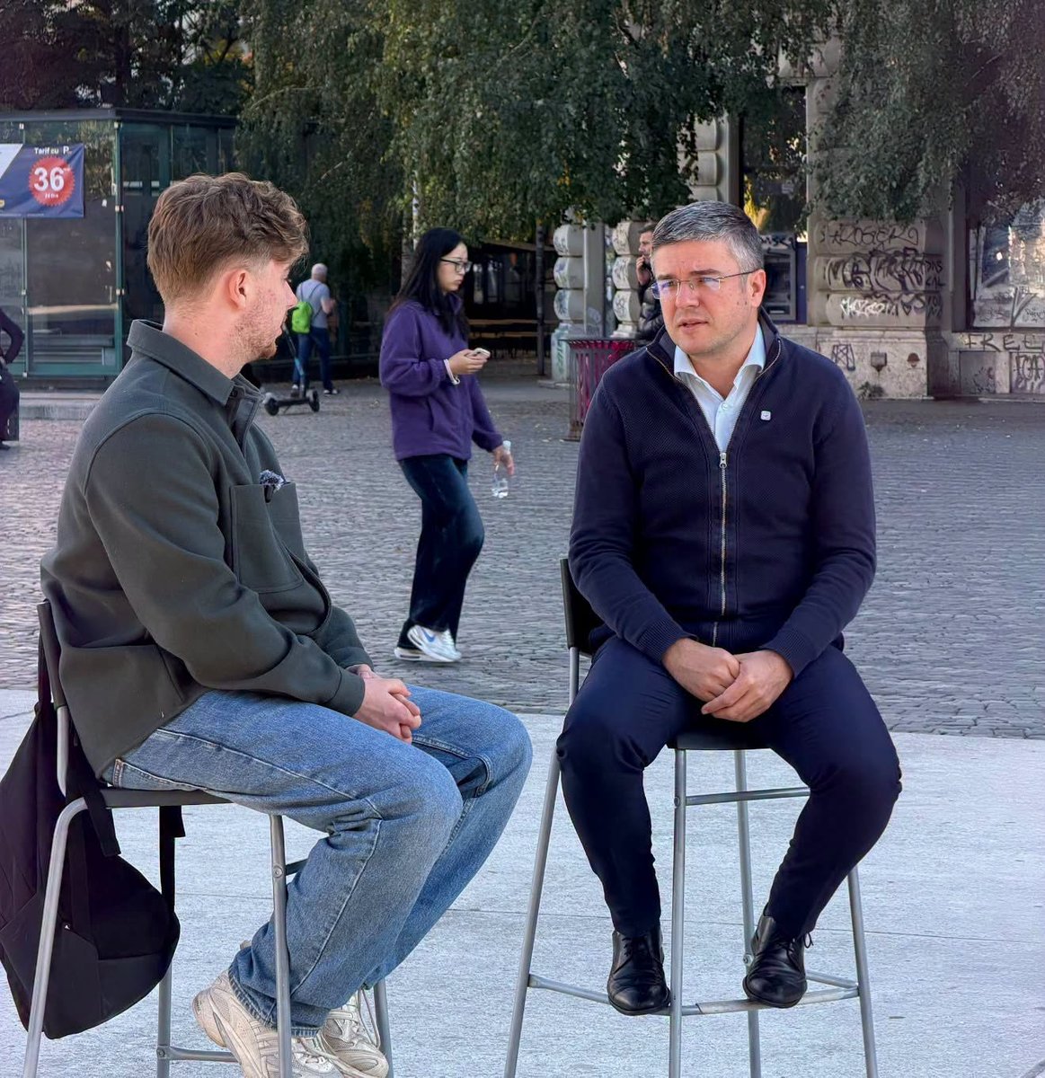 Ellunes's tweet photo. Ministrii USR s-au dus in Piata Universitatii.
Ministra de Externe, Oana Țoiu, si ministrul Economiei, Irineu Darău, au asezat doua scaune si au invitat trecatorii la dialog.

Niciunul dintre ei nu a avut 12 bodyguarzi lângă el.... Ce chestie! https://t.co/vqhZcYIFSa