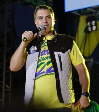 GamaDaMissao's tweet photo. Flávio Bolsonaro acena à Missão, usando as cores do partido. Droga, eu iria de 22 no segundo turno, mas agora vou ter que votar no 14. https://t.co/QaObkYv9xP