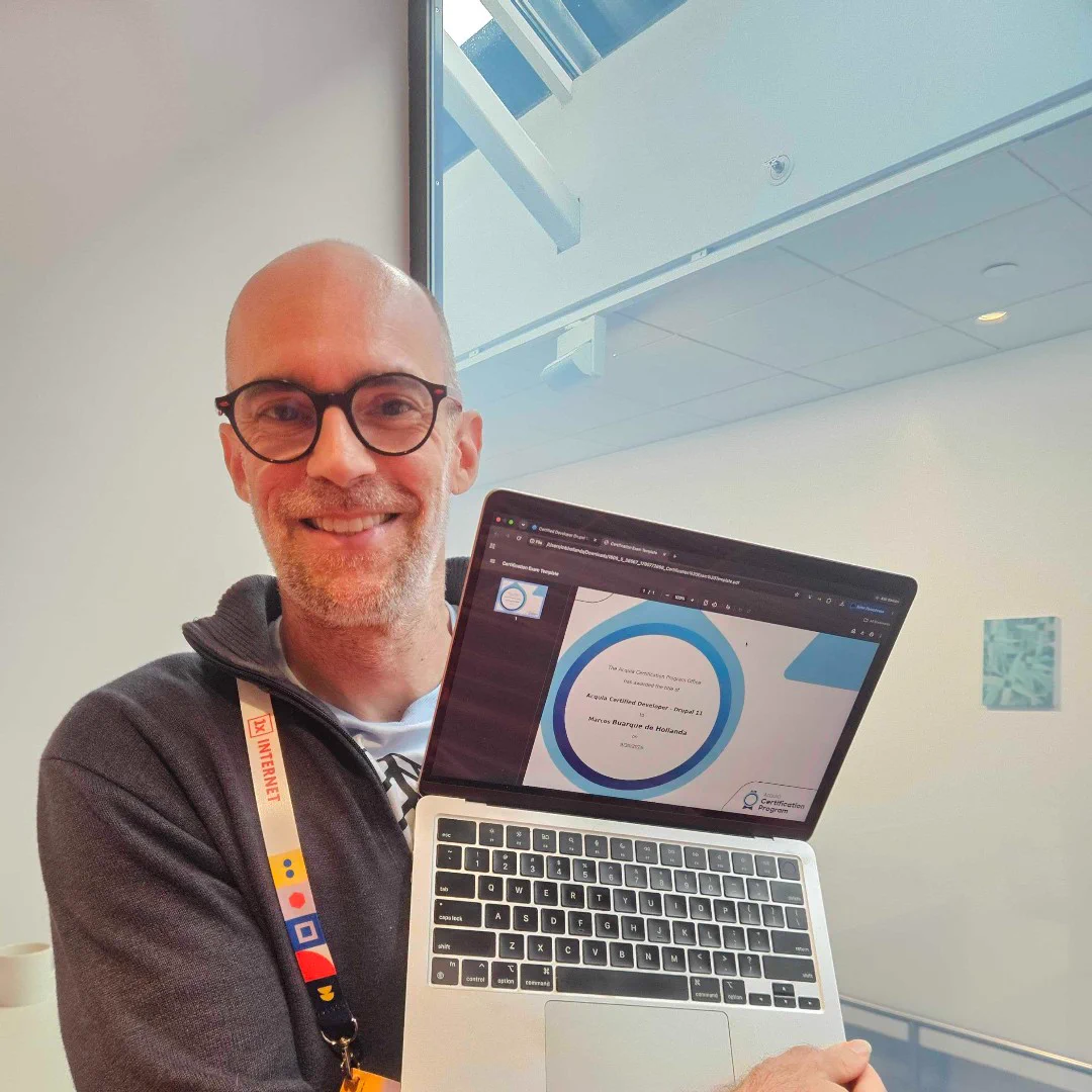 Smiling man with glasses holding a laptop displaying a circular data chart in a bright modern office space.