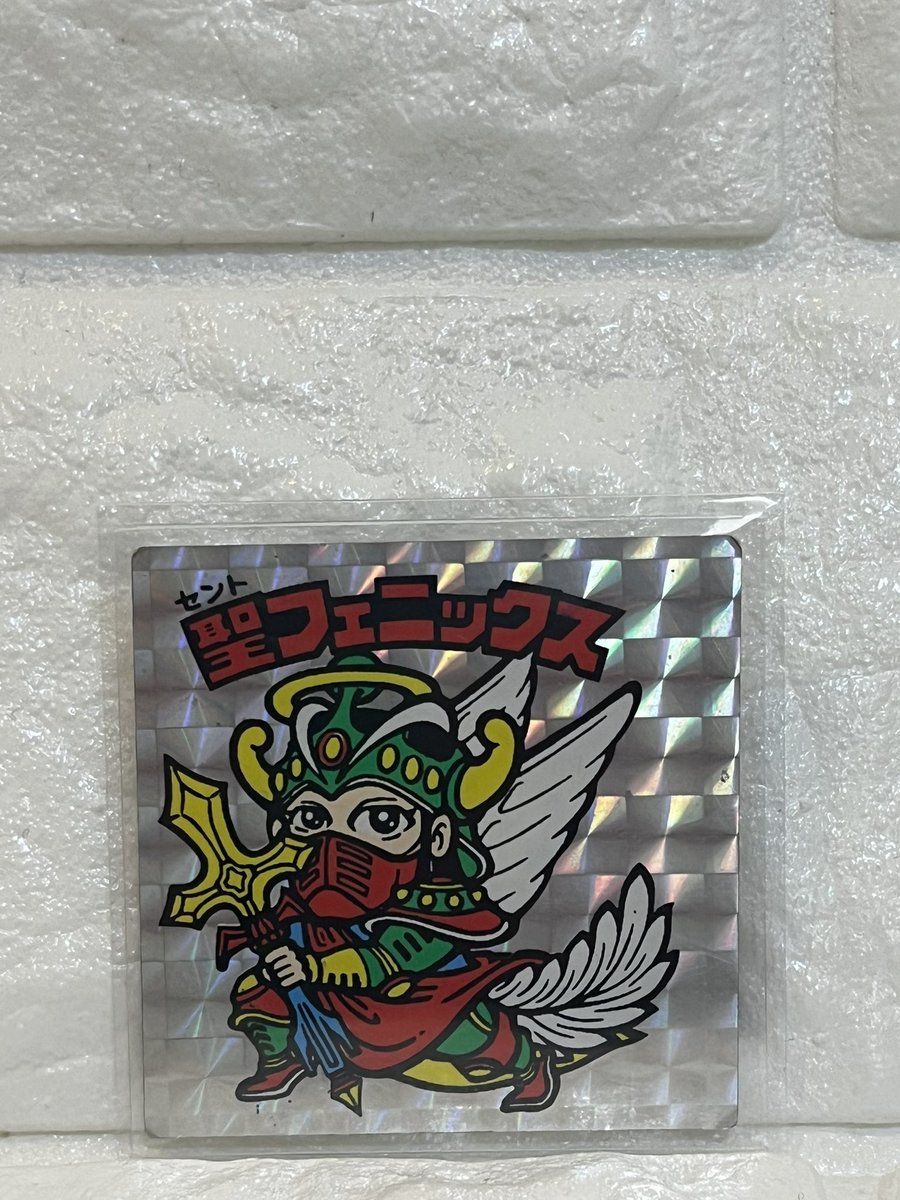 nishida_ta17277's tweet photo. ビックリマン有識者の皆様、教えて下さい。
先日オークションサイトで購入した聖フェニックスなんですが、左に凄く寄ってます。
これって何版なんでしょう？
チョコ版、アイス版、懸賞版、エラー品、パチシール、色々と調べたんですが同じようなシールがなく答えが出ませんでした。#ビックリマン https://t.co/Lva1NktLpY