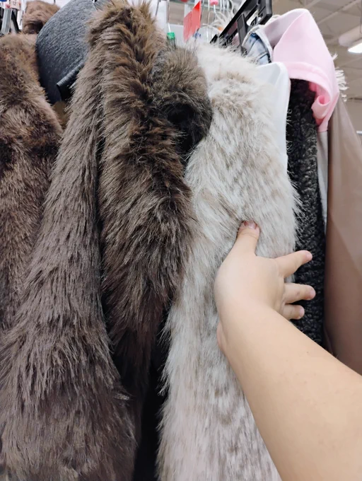 A photo of my irl arm, touching some fur jackets/coats.