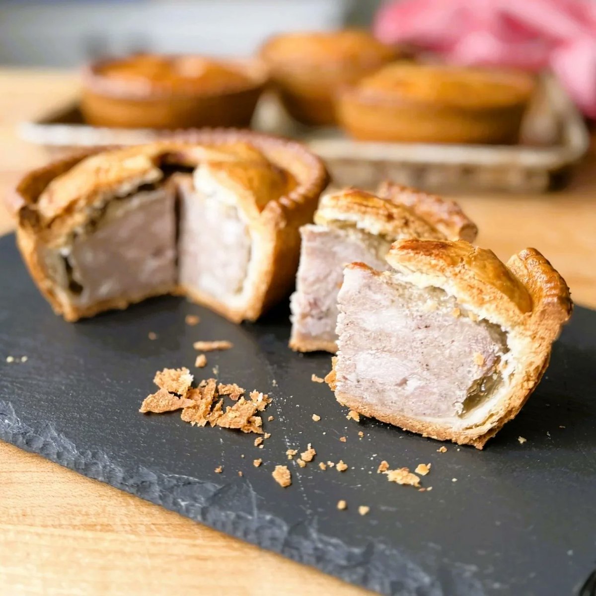 SamaHoole's tweet photo. A Melton Mowbray pork pie is pork, wrapped in pork fat, sealed with pork jelly. It was built to survive a day in the coat pocket of a man on a galloping horse.

The pastry is like no other. You boil water with a block of lard until it melts, pour it hot into the flour, and work it while it is still warm. The result can be raised by hand into a tall case that will stand up on its own. It bakes as hard as a tin.

The filling is fresh pork, chopped with a knife, with nothing added but salt and pepper. It cooks grey, the colour of a roast, and a real one is never pink.

Then comes the clever part. As the meat cooks it shrinks away from the crust and leaves a gap. So when the pie comes out of the oven, hot stock made from boiled trotters is poured in through a hole in the lid. It sets into a jelly that fills every space and shuts out the air. That is what makes the pie keep.

It was the food of the hunting field. The grooms and riders of Leicestershire needed something that would not fall apart at a fence, and from the 1830s Melton was sending them to London by stagecoach.

And the pork was there for a reason. The same countryside makes Stilton. Cheesemaking leaves gallons of whey, and whey fattens pigs. The cheese fed the pig, and the pig became the pie.

The recipe has been protected by law since 2009.

Every part of it breaks a modern rule. It is also a complete meal you can eat with one hand, that needs no fridge and no packaging, and they solved it 200 years ago with a pig.