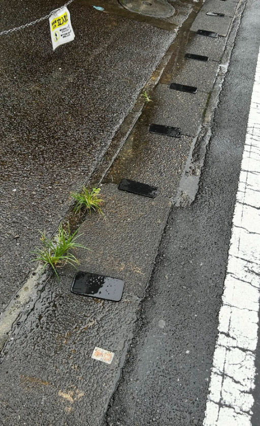 IATheophilus's tweet photo. 道歩いてたら
スマホが何台も道路脇に転がってて普通に二度見したw

最初は誰かが落としたのかなって思ったんだけど
1台じゃないの見て一気に意味分からなくなった、、、

これどういう状況？ https://t.co/7eJPXrthpl