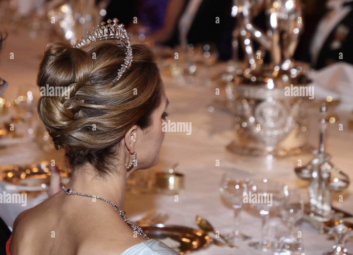 RNN_RoyalNews's tweet photo. Princess Madeleine of Sweden wore her Modern Fringe Tiara and also the Edward VII Ruby Tiara as a necklace. However, the necklace did have a bit of a disappearing act. She wore it for the greeting and into the dining room, as shown in the photo of her sitting with it on, viewed from behind. But when the camera moves around to the other side of the table, it's gone. It's an older piece, so I wonder if the clasp broke or something and they had to retire it for the evening.