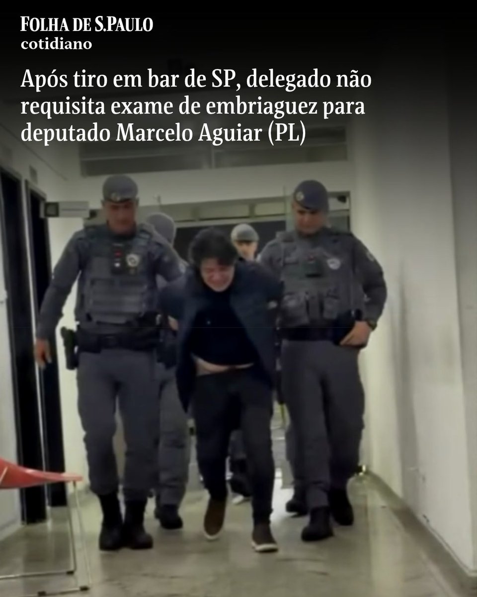 folha's tweet photo. O delegado da Polícia Civil responsável por registrar a ocorrência da detenção do deputado estadual Marcelo Aguiar (PL) não requisitou exames que poderiam ter comprovado eventual embriaguez do parlamentar. Ao ser detido por policiais militares após um disparo de arma de fogo em uma casa noturna, Aguiar mal conseguia se manter em pé. Vídeos gravados na porta do 14º DP (Pinheiros), na zona oeste de São Paulo, mostram o deputado sendo amparado o tempo todo, do desembarque da viatura até a entrada em uma sala da delegacia. O boletim de ocorrência não menciona exame de dosagem alcoólica ou toxicológico. A reportagem questionou a Secretaria da Segurança Pública sobre a falta de teste de embriaguez. Não houve resposta. A pasta disse que a "investigação é conduzida pela 3ª Delegacia Seccional de Polícia, que adota as providências necessárias ao inquérito, como a solicitação das imagens das câmeras de segurança do estabelecimento comercial".

📲Leia mais na #Folha: https://t.co/5oFsWVrx2z

📷 Reprodução/TV Globo
📝 Paulo Eduardo Dias

#PraTodosVerem: Dois policiais escoltam Marcelo Aguiar por um corredor interno branco. O homem está com a cabeça baixa e os policiais seguram seus braços.
