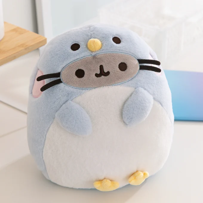 A plush of Pusheen dressed as a blue penguin with yellow feet and a beak.