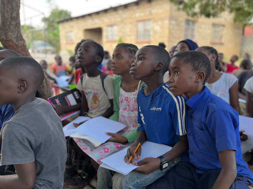 AEProgram's tweet photo. A strong start in life can shape a child’s entire learning journey. Yet in #Zambia, fewer than 35% of children entering Grade 1 have experienced formal pre-primary education, according to @UnicefZambia—highlighting the importance of supporting children’s development before school and throughout the early primary years.

Play-based learning helps build that foundation. Through art, native games and hands-on exploration, children develop language, creativity, social skills and confidence. These opportunities remain valuable as children move into primary school, helping them participate actively and find joy in learning.

At the African Education Program’s flagship Learning & Leadership Center in Kafue, Zambia, that approach comes to life under the shade of a mango tree. Here, Chanda, Amos Youth Centre’s Young Learners Program Coordinator and teacher, leads Grade 3 and 4 students in an outdoor art activity, encouraging them to explore ideas and express themselves.

Through the Young Learners Program, more than 400 girls and boys have a nurturing space to strengthen foundational skills, build friendships and grow as confident learners. Investing in these early years helps children build the skills they will carry into every classroom—and throughout their lives.

#EarlyChildhoodDevelopment #LearningThroughPlay #YoungLearners #AfricanEducationProgram