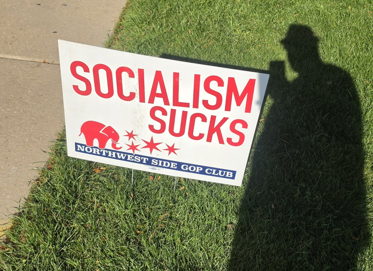 NotBadgers's tweet photo. I was walking up to my polling place, thinking about all the Socialism I was going to vote for. Then I saw this sign, and stopped dead. In 47 years on this Earth, no one has ever told me that Socialism sucks. I threw away my trilby and bought a #MAGA hat right then and there. https://t.co/pOUKiqhpsY