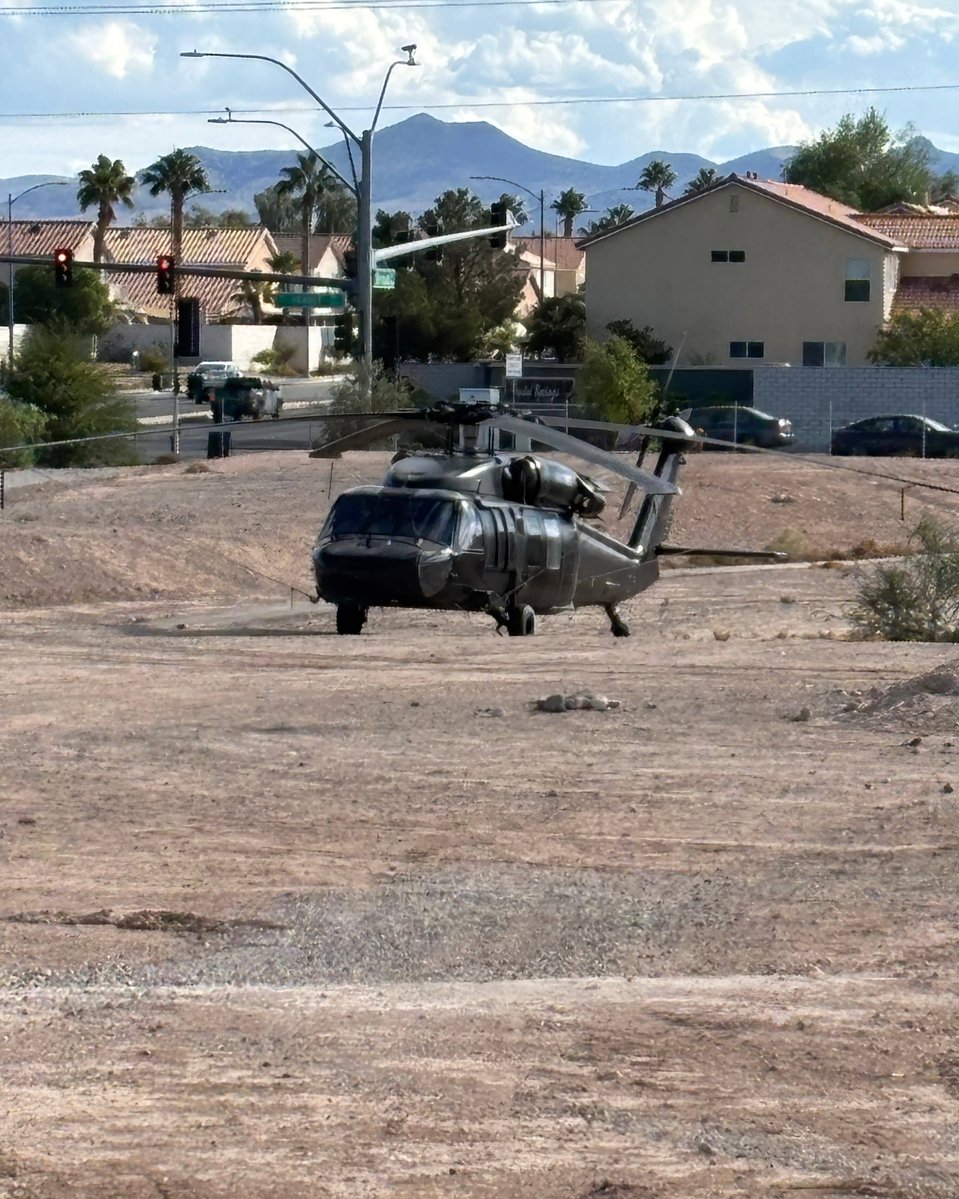 LasVegasLocally's tweet photo. A Black Hawk helicopter has been parked on a dirt lot in a Las Vegas neighborhood for 4 days.

Its pilot is in town for a convention.

The landowner near Bermuda and Pebble says he OK'd it — and that the FAA did too.

Still cheaper than resort parking.

(📸 FOX5 Vegas) https://t.co/GC27Kkha4S