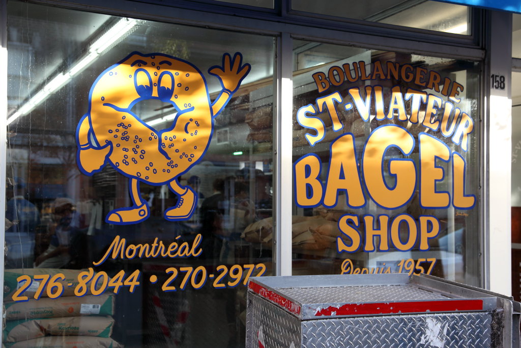 EIT's tweet photo. A rosemary and sea salt bagel, more sweet than salty, from St-Viateur Bagel, Montreal. Also shown: a nearby bagel prohibition zone; seating carved out for passers-by. https://t.co/ptPW4Dluud