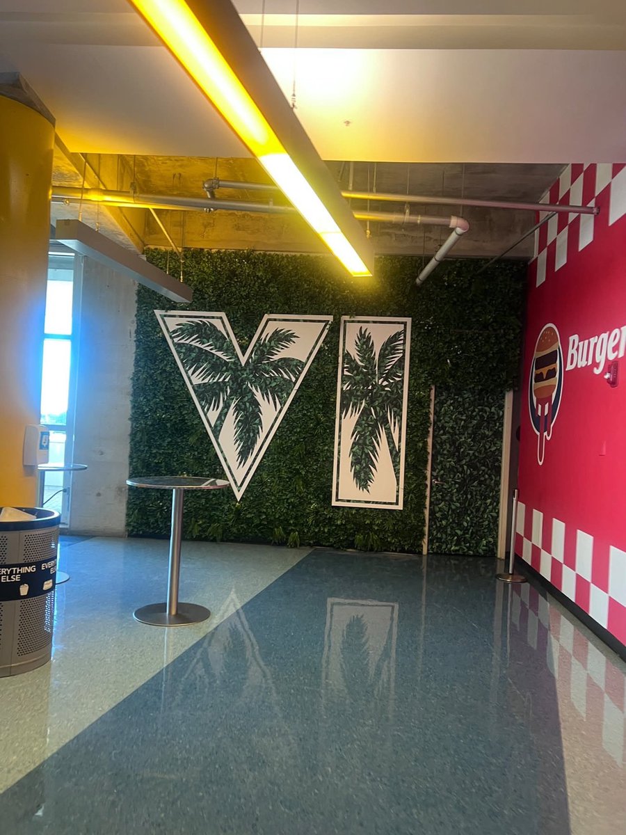 KingZezim_Kalux's tweet photo. O Burger Shot saiu do GTA para ganhar espaço no mundo real! O restaurante do Kaseya Center, em Miami, adotou a identidade da rede fictícia, e a arena também recebeu cartazes de Vice City e Macca & Friends como parte da divulgação do GTA 6. (via @GTAVI_Countdown / @nvtnp_ / @videotech) #GTAVI