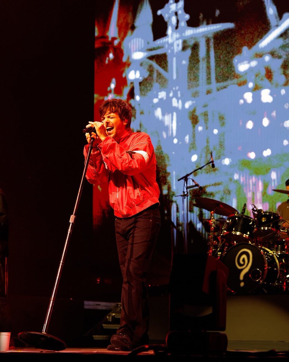 LTUpdatesPL's tweet photo. Następnie koncert przenosi się do bardziej kameralnej scenerii, gdy Tomlinson i jego zespół przenoszą się na scenę B. Atmosfera zmienia się wraz z jego solowym wykonaniem utworu „ Night Changes” , sentymentalnym ukłonem w stronę czasów One Direction, który budzi nostalgię wśród wieloletnich fanów. Następnie „Lazy”, „Sunflowers” ​​i „Lucid” oferują zmianę tempa i przybliżają publiczność do muzyki, gdy Tomlinson nawiązuje bliski kontakt z fanami, stojąc na środku sceny.

Po powrocie na główną scenę, Jump the Gun rozpoczyna kolejną część występu. Tomlinson przyznaje również, że jego poprzedni występ w Melbourne w 2024 roku był momentem pełnym emocji, dziękując fanom za to, że pozwolili mu wtedy wyrazić swoją wrażliwość i za to, że nadal go wspierają. To wzruszające uznanie dla relacji, jaką zbudował z publicznością, potwierdzające jego więź i rozwój z fanami, którzy pozostali z nim na tej drodze.

Tomlinson nadal daje koncert, który łączy siłę rockowych inspiracji z wrażliwością i więzią, które ukształtowały jego solową karierę.

 Imposter i Sanity utrzymują rytm koncertu, a Last Night, The Spark i Kill My Mind przynoszą kolejną dawkę energii.

Face the Music i Silver Tongues kontynuują występ, a ten ostatni szczególnie dobrze oddaje atmosferę wspólnoty i unoszenia rąk w powietrzu, która wypełnia arenę. The Observer zapewnia chwilę refleksji, zanim Tomlinson wróci na scenę B, by wykonać akustyczny utwór The Answer – wyciszenie przed finałowym akcentem.

Po powrocie na główną scenę ponownie się otwiera. Zapytany przed koncertem, czy nadal się denerwuje, przyznaje: „Jestem cholernie zdenerwowany przed każdym koncertem”. Następnie wyraża swoje szczęście, że może występować przed tak kochającą publicznością, dając jasno do zrozumienia, jak wiele znaczy dla niego ich wsparcie. Miss You i Palaces grają bis, wprawiając arenę w kolejny, ogromny, wspólny śpiew, kończąc wieczór w emocjonalnym tonie.

©The Music Au
fot. Jonathan White @objetperdu
