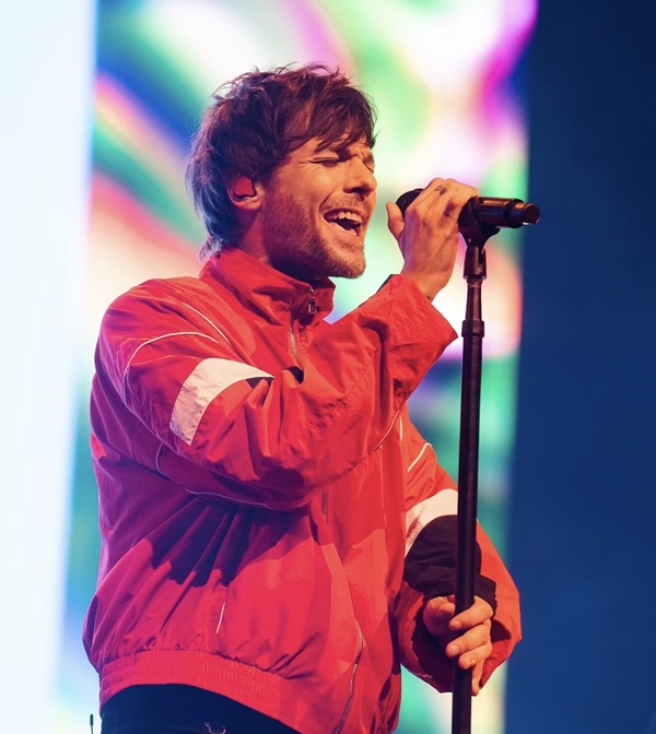 LTUpdatesPL's tweet photo. 📝 Louis Tomlinson zachwyca Melbourne podczas elektryzującego koncertu w ramach światowej trasy „How Did We Get Here?”

Louis Tomlinson był dla mnie jednym z największych zaskoczeń w Arenie John Cain. Oczywiście wiedziałem, jak wielką popularnością cieszył się jeszcze w czasach One Direction, ale nie zdawałem sobie sprawy, jak wielki jest jego talent dopóki nie usłyszałam go na żywo. I powiem Wam jedno - on zdecydowanie wie, jak urządzić show! Występując w ramach światowej trasy „How Did We Get Here?”, Tomlinson nie marnuje zbyt wielu słów między piosenkami, ale z nawiązką nadrabia to muzyką. Wspierany przez absolutnie fantastyczny zespół, dał pełen energii koncert wypełniony potężnym wokalem, elektrycznymi gitarami i atmosferą, która przypomina, jak wyjątkowa potrafi być muzyka na żywo.

Jego brzmienie określiłbym jako indie rock, rock alternatywny i odrobina popu. To kierunek muzyczny, który wyraźnie odróżnia go od czasów One Direction - z surowym, opartym na gitarach sznytem i chwytliwymi melodiami, które sprawiają, że jego utwory są tak pociągające. 

Rozpoczynając od „Lemonade”, Tomlinson natychmiast postawił publiczność na nogi, przechodząc do fantastycznej setlisty, która obejmowała m. in. „On Fire”, „Written All Over Your Face”, „Out of My System”, „Saturdays” oraz „Kill My Mind”.

Jednym z najbardziej pamiętnych momentów wieczoru było wykonanie utworu „Night Changes” z repertuaru One Direction. Usłyszenie tego uwielbianego hitu na żywo było pięknym przypomnieniem, gdzie zaczynała się jego podróż, a sądząc po reakcji publiczności, piosenka ta wciąż zajmuje szczególne miejsce w sercach fanów. Nie zabrakło też genialnej interpretacji „My Hero” Foo Fighters, co pokazało inne oblicze jego talentu muzycznego i udowodniło, że jego głos czuje się w rocku równie swobodnie, co w popie.

Choć Tomlinson nie przepada za długimi pogawędkami między utworami, znalazł chwilę, by wyznać, jak wiele znaczy dla niego Melbourne. „Przyjeżdżam tutaj, odkąd miałem 19 lat” - powiedział fanom. „Uwielbiam tu spędzać czas. To wspaniałe miejsce, wspaniała pogoda i dobrzy ludzie. Mamy tu dobrego kumpla, więc to miłe”. Kontynuował, wspominając swoją długą więź z Australią i dodając, że przyjeżdżanie tu przez większą część ostatnich 15 lat było „czymś wyjątkowym”. Był to uroczy moment, przypominający, że pomimo międzynarodowego sukcesu Tomlinson nie zapomniał o miejscach i ludziach, którzy wspierali go przez całą karierę.

Najbardziej zaimponowała mi jego swobodna prezencja sceniczna. W tym występie nie było nic zbędnego. Był tylko Louis, jego niesamowicie utalentowany zespół i tysiące uwielbiających go fanów śpiewających każde słowo razem z nim.

Wieczór dopełniły utwory „Miss You” oraz „Palaces”, co stanowiło wspaniałe zamknięcie tej muzycznej nocy.

Poszedłem na koncert, znając Louisa Tomlinsona jako jednego z chłopaków z One Direction. Wyszedłem z zupełnie nowym uznaniem dla niego jako solowego artysty.

Czyż to nie jedna z najwspanialszych rzeczy w muzyce na żywo? Odkrywanie, jak utalentowany jest w rzeczywistości artysta, kiedy doświadcza się go na własne oczy. Louisie Tomlinsonie, zdecydowanie mnie urzekłeś i podejrzewam, że nie byłem jedyny!

©️melbournemystyle