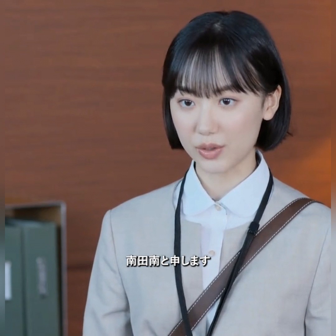 A close-up scene shows a young woman with a short bob haircut wearing a white collared shirt and lanyard; the Japanese subtitle reads “南田南と申します.”