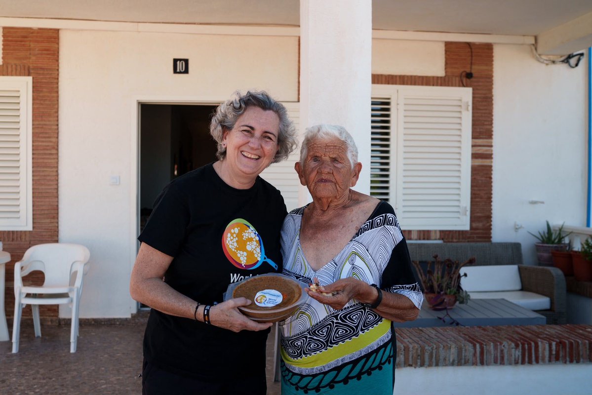 WCKitchen's tweet photo. As communities in Alicante and Valencia begin to recover after the flooding caused by DANA Adam, WCK is reaching people in need with hot meals—including door-to-door deliveries in Oliva. There, Chef Pepa met 90-year-old Marisa, who told us that her 92-year-old husband uses a wheelchair and her 88-year-old sister has epilepsy. Bringing meals directly to their door makes a world of difference to families like Marisa’s. Every hour matters, which is why it’s critical for our teams to stay prepared.
“Getting our teams, ingredients, equipment, and local partners ready before the water arrives means we can move quickly and focus on feeding communities when they need us most,” said Pepa. #ChefsForSpain

Mientras las comunidades de Alicante y Valencia comienzan a recuperarse de las inundaciones causadas por la DANA, WCK está en el terreno llevando comidas calientes a quienes más lo necesitan, incluidas entregas puerta a puerta en Oliva. Allí, la Chef Pepa conoció a Marisa, de 90 años, cuyo marido de 92 años utiliza silla de ruedas y cuya hermana de 88 años tiene epilepsia. Para familias como la de Marisa, recibir la comida en la puerta de casa marca una diferencia enorme.
“Preparar a nuestros equipos, ingredientes y socios locales antes de que llegue el agua significa que podemos movernos rápidamente y centrarnos en alimentar a las comunidades cuando más nos necesitan,” dijo Pepa. #ChefsForSpain