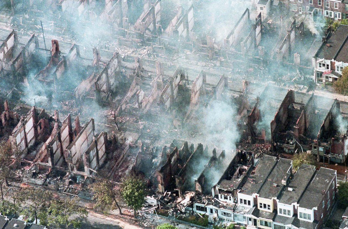 Newrawriot's tweet photo. 1985 MOVE bombing
police dropped explosives on the house, causing a fire and the police opted to "let the fire burn", resulting in the destruction of 61 homes and the death of five children and six adults. The police fired on those trying to escape the raging flames. https://t.co/CTPO6CYkD7