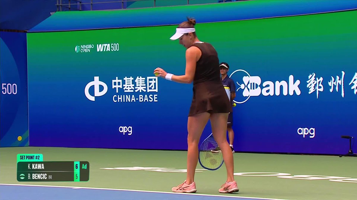 Katarzyna Kawa prepares to serve on court at the Ningbo Open, with the scoreboard showing “SET POINT #2” and her leading B. Bencic 6–5 in the first set. The broadcast graphic reads “WTA 500,” supporting the post’s report that Kawa won the opening set 7–5.