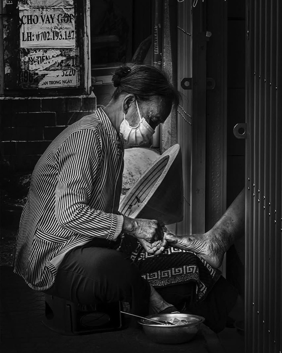 vca_bucket2011's tweet photo. Gentle hands, quiet dedication. An elderly woman works in a tucked-away corner, her conical hat at her side. A black-and-white portrait of grace, labor, and connection on Vietnam’s streets. https://t.co/KZsMk7ETJR