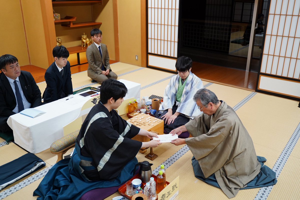 chunichishogi's tweet photo. 藤井聡太竜王に服部慎一郎七段が挑む第39期竜王戦七番勝負の第2局は、藤井聡太竜王が手を封じ、1日目の対局を終えました

明日午前9時に再開です

封じ手時の写真（日本将棋連盟提供）です https://t.co/kc5jpliQYt