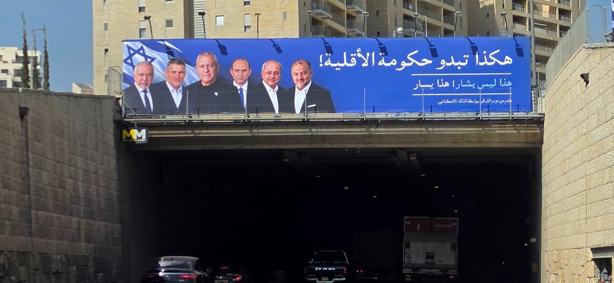 yanircozin's tweet photo. ספוילר: זו אינה כרזה של ישר!

בדרך בגין בירושלים מופיע השלט הזה בערבית בצבעי הקמפיין של ישר! בו נראים איזנקוט, גולן, ליברמן, בנט, טיבי ומנסור עבאס.

לנוסע במהירות בבגין זה נראה כמו כרזה של איזנקוט בערבית המתארת לכאורה את ממשלתו העתידית, המסר פשוט וברור ואמור לייצר הטעייה אצל הנוסעים. אבל בתכלס זה פשוט שלט של הליכוד שנעשה ב-AI עם הכיתוב הרגיל של קמפיין הליכוד אבל בערבית.

אגב, זה מעצים את ההטעייה של הליכוד כשבצומת לפני ואחרי ישנם שלטים אמיתיים של איזנקוט באותם צבעים.