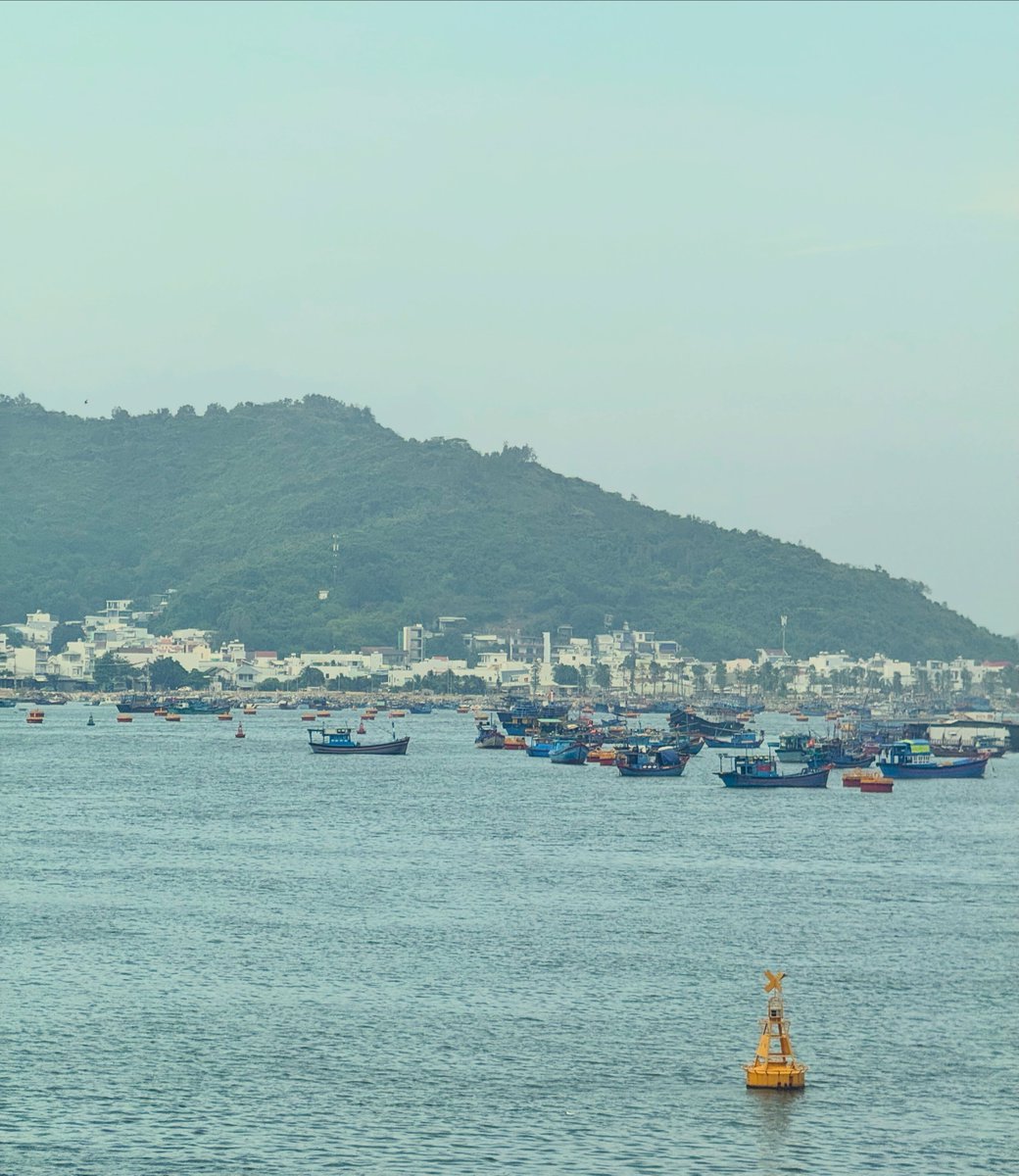 shaunyb1's tweet photo. Calm seas, misty mountains, and fishing boats on the horizon. One of those peaceful Vietnam moments you want to remember. https://t.co/haMpgamMLy