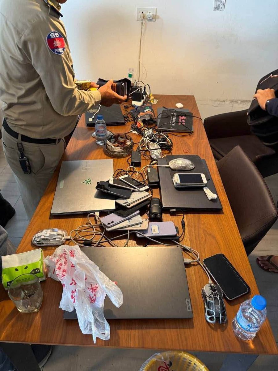 Cambodiataro's tweet photo. 【特殊詐欺ニュース】プノンペンの日系コンドミニアムでオンライン詐欺の摘発　現地メディアでは報じられない水面下の取り締まり

カンボジアの首都プノンペンにあるコンドミニアム・ボタイジュレジデンスにおいて、現地警察当局によるオンライン詐欺拠点の摘発が行われたことが、SNS上に流出した現場写真から明らかになりました。  

▪️SNSに投稿されたC棟での拘束写真と押収端末

現地の社会動向などを発信しているノアン・セレイボット氏は2026年10月22日、自身のX（旧Twitter）アカウントにて「プノンペン当局は昨日、ボダイジュ・レジデンスでオンライン詐欺の取り締まりを行った」と投稿し、2枚の現場写真を公開しました。  

公開された1枚目の写真には、同コンドミニアムの「BLOCK C」と記された緑色の案内標識がある共用廊下にて、カンボジア国家警察の制服を着た多数の警察官が取り囲む中、両手を結束バンドで縛られた複数の男性が床に座らされている様子が写っています。廊下のガラス扉には、同物件のロゴマークも確認できます。  

もう1枚の室内を撮影した写真には、木製のテーブルの上にノートパソコン5台、スマートフォン約18台、マウスや多数の充電ケーブル類、中国語の文字が記された黒い冊子などが並べられ、警察官が押収されたスマートフォンを束ねて確認している状況が記録されています。比較的小規模なグループが、一般の居住用ユニットを拠点として詐欺行為を行っていたことをうかがわせます。  

▪️プノンペン国際空港近くの大型コンドミニアム

今回摘発の現場となったボタイジュレジデンスは、プノンペン国際空港に近いポーセンチェイ区に位置しています。日本の不動産投資・開発企業であるクリードグループが開発した日系プロジェクトであり、14階建て全6棟・約900戸を有する大型コンドミニアムとして知られています。日本人投資家や現地在住者にも馴染みのある物件です。

▪️現地メディアでは報じられない摘発の実態と「公表」を分ける背景

注目すべき点として、今回の10月21日に実施されたとみられる摘発については、10月23日現在、現地主要メディアでは一切報じられていません。警察当局からの公式なプレスリリースも出されていない状況です。

カンボジアでは2025年後半から2026年にかけて政府主導のオンライン詐欺取り締まりが強化され、かつてのような大規模な専用施設での活動が困難になった結果、犯罪グループがプノンペン都内の一般のコンドミニアムやサービスアパートメントなどに小規模な単位で分散・潜伏するケースが相次いでいます。

こうした小口分散化の動きに対し、現在プノンペン都内では郊外のみならず都心部においても、コンドミニアムやサービスアパートメントに対する当局の立ち入り検査が極めて高い頻度で実施されています。実際に数多くの物件で摘発や身柄の拘束が行われていますが、そのすべてが公式に発表され、ニュースとして報じられているわけではありません。

立ち入り検査や摘発が入った際、その事実が公式発表されてメディアで一斉に報じられるか、あるいは表沙汰になることなく水面下で静かに処理されるかの分かれ目には、物件オーナーらによる当局や関係者への特別な働きかけや、相応の配慮・交渉の有無が大きく影響しているのが現地の暗黙の実情とされています。

当局は主要な摘発成果を公表する一方で、今回のように一般のコンドミニアムの1室や数室を対象とした小規模な立ち入り検査・摘発については、公式発表を行わないケースが多々あります。公式報道として可視化される事案は氷山の一角に過ぎません。

今回SNSを通じて流出した2枚の写真は、一般の高級コンドミニアムやサービスアパートメントにも詐欺グループが浸透している現状と、表向きには報じられない水面下での摘発、そして情報を巡るカンボジア特有の力学が日常的に働いているリアルな実情を静かに物語っています。