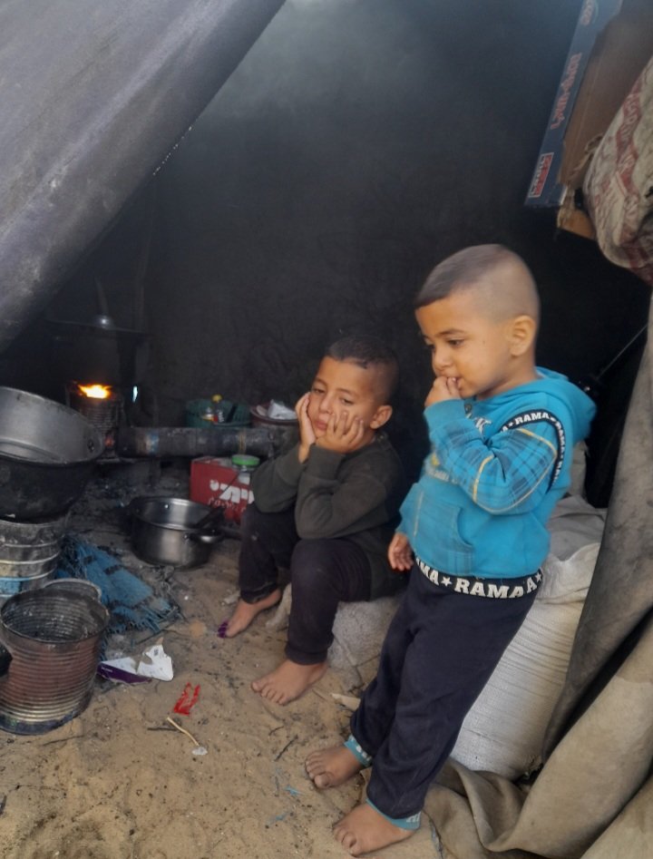 anas___1990's tweet photo. This is how we live in Gaza under the weight of genocide and displacement. Children have been deprived of their most basic rights, living inside a tent surrounded by dirt and fire instead of the warmth of a home and the safety of childhood.
My children do not dream of toys or a luxurious life, but simply of a meal to satisfy their hunger, a home to protect them, and days when they no longer have to fear tomorrow. 
 Help carry the voices of Gaza’s children to the world. Perhaps your words can help bring support to my family and others suffering through this hardship.
https://t.co/juhZUvafMS
