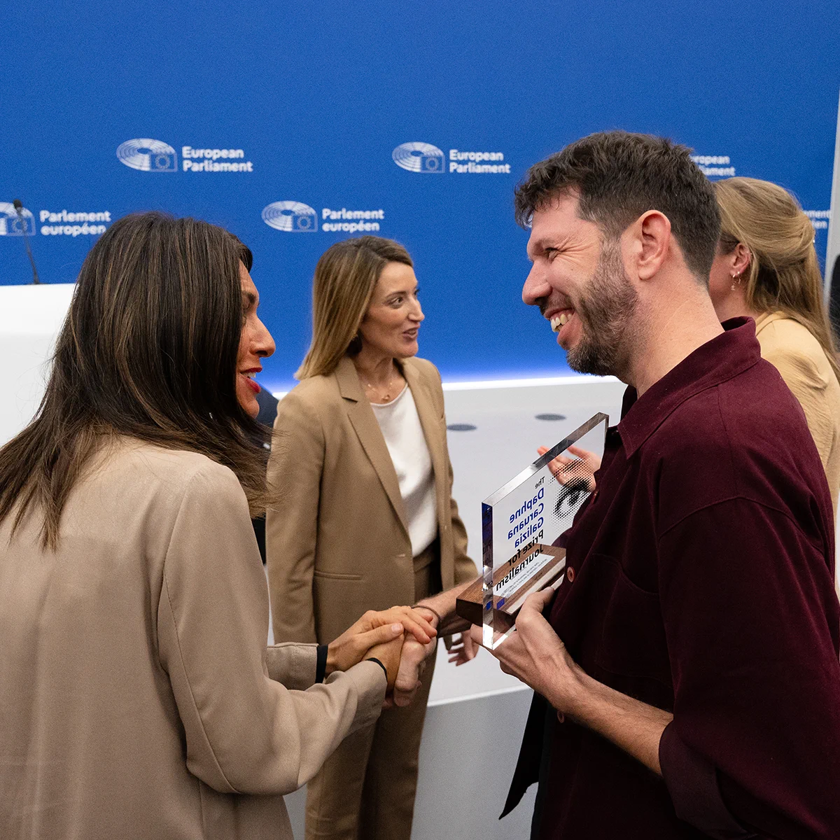 Journalists Giacomo Zandonini and Maite Vermeulen shaking hands with the European Parliament President Roberta Metsola and Vice-President Pina Picierno, while holding the Daphne Caruana Galizia Prize for Journalism trophy at the award ceremony in the European Parliament.