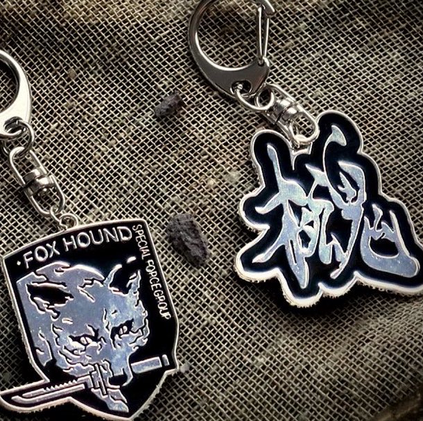 k42wKKihKBGTvXv's tweet photo. 「METAL GEAR」エンブレムがメタルキーチェーンになってカプセルトイで登場決定！！！

#最新情報　#カプセルトイ https://t.co/hGD7a4Nhjj