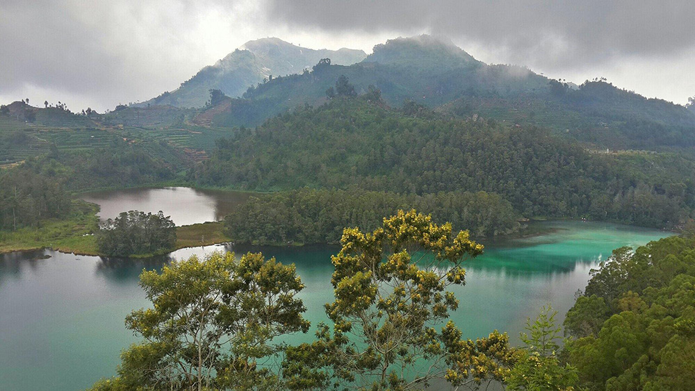 Naanbu's tweet photo. Telaga Warna in Dieng, Indonesia, shifts through shades of green, yellow, and blue as light and clouds move across its surface. Surrounded by misty forests and mountain views, it’s one of Central Java’s most magical natural escapes. https://t.co/4SZaY7A9KO