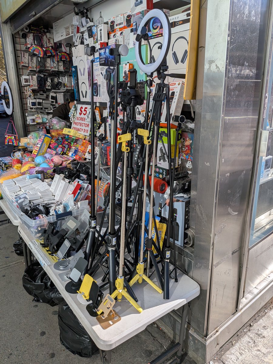 TedMerz's tweet photo. I like how this magazine stand in the Lower East Side sells the standing influencer selfie sticks with light rings. https://t.co/zw2qS7JVqy