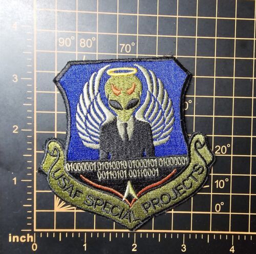 uncannyex's tweet photo. It is associated with a Groom Lake program. Paglen's book is only a very tiny fraction of the program patches out there. Important to remember that can't take the imagery literally. It's a cheeky nod to the Tr-3b rather than "confirming" that it exists. Also see this one from AFOSI/PJ.