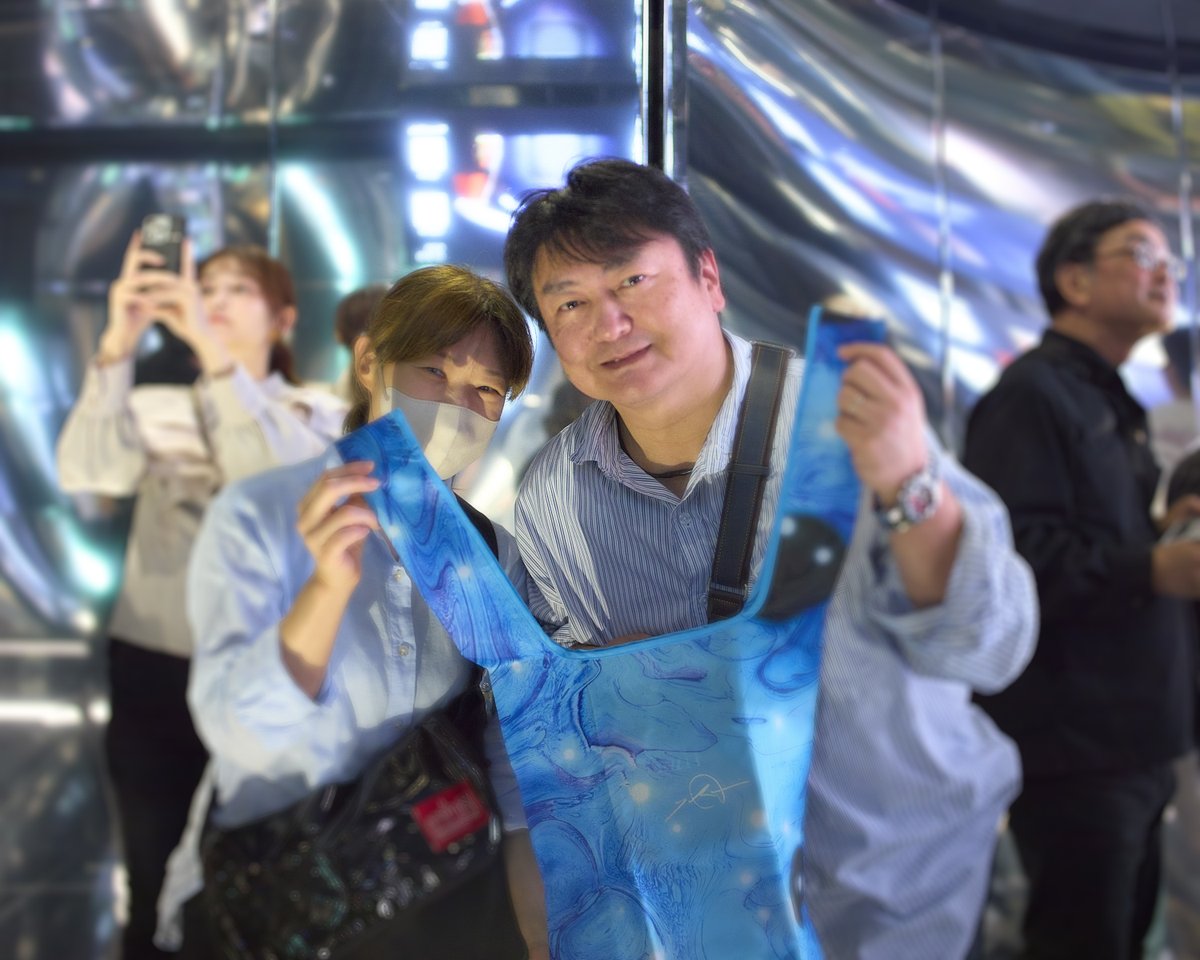 null2_nexus's tweet photo. 【TOPICS |祝！ご来場者1万人達成!!】

オープンから2度目の週末も大入り満員御礼申し上げます。
本日17:20入場回にて1万人目のお客様をお迎えしました！

幸運なお客様は大阪・関西万博でnull²に入れずやっと来られた神奈川県在住のお二人。
1万人目を記念して落合陽一直筆サイン入エコバッグなどを進呈させていだきました。

▶︎雨天でも安心屋内全天候対応null²ⁿチケット販売中！
https://t.co/QLo8svYuEi

#落合陽一 #ﾇﾙﾇﾙネクサス #null2 #null2n #null4 #大阪関西万博 #EXPO2025 #アフター万博 #横浜