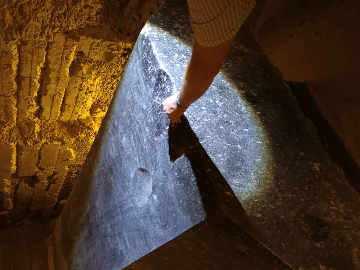 FoMaHun's tweet photo. Polishing a 70-ton, supposedly granite box to a mirror finish with a copper chisel and sand is like digging your basement with a toothpick.

Underground at Saqqara, along tunnels cut into the bedrock, there are about two dozen giant stone boxes (sources say 24 or 25), each sitting in its own niche. This is the Serapeum.

The official story: it's a burial place for the sacred Apis bulls. Except the boxes are empty, and big enough for a bull to stand up in. Must have been cozy. 🐂

Their weight is up for debate. In my book I cautiously wrote 20–40 tons and up, and plenty of sources put the biggest ones at 60–70+ tons, with lids around 30 tons.

Nobody has ever actually put one on a scale, so let's just say they're heavy. Insanely heavy.

The material is supposedly granite, hauled from Aswan, roughly 800 km away. That second part I'm not buying. I've been there, and these boxes come in every shade from pink to black.

So let's see how they were made, according to the official version!

Step one: they bashed out a huge block with dolerite pounders, then hollowed it out. A few months, done.

Then they grabbed a copper chisel. Copper, mind you, is way softer than granite. With it they carved everything nice and square.

Finally came the sand, and they rubbed the surface until it shone like a mirror.

Sure. A hundred percent that's how they did the inner corners 🤣

The outside I can almost picture: twenty guys standing around it, whacking away. But the inside walls? The inside corners?

Then they dragged it into the tunnel.

The niches are tight, and so are the corridors. If it takes ten men to move a ton of stone, a 70-ton box needs seven hundred strong lads. Where do they stand? On each other's shoulders?

Hey engineers, I'd love to see that logistics plan drawn up just once!

And what about the famous mirror-flat walls and perfect right angles?

Years ago Christopher Dunn argued that this kind of precision needed advanced ancient technology. Later, others measured the boxes with better instruments, and the surfaces and angles deviate exactly as much as you'd expect from handwork. Oops!

The surface is still weird, though. It's not just the flat parts that shine, but the bottoms of palm-sized dents and tiny flaws too.

You could only pull that off with a UFO 👽 and a polishing disc, because a regular one can't reach the bottom of a dip.

On top of that, the underside of one displaced lid shows dried drip marks. Like someone painted the edge of a board and the paint ran down underneath.

That's not polish. That's a coating. 💡

What could the coating be? Waterglass, i.e. sodium or potassium silicate. See my experiment from last month. At room temperature!

I brushed waterglass onto the rough, unpolished side of a piece of red granite, and it turned into a hard, glassy surface.

So where does waterglass come from? You have to dissolve stone for it, not hammer it.

The recipe is simple if you don't mind a bit of kitchen chemistry: dissolve natron in lye made from wood ash, then stir in quicklime. That caustic mix starts eating stone at around 168 °C. That's a kitchen oven, not a furnace.

That's why I think these boxes aren't carved granite at all, but cast artificial stone, poured right there in the niche.

No need to cram seven hundred men into a corridor. Just carry buckets. 🧱

Granite is a touchy subject anyway: half of all "granite" kitchen countertops are really crushed stone plus a binder. Only there the binder is resin, not waterglass.

So we have an official explanation where a copper chisel carves stone harder than itself, a dolerite ball turns into an inside corner, sand reaches the bottom of every dent, and seven hundred men fit in one corridor.

Hats off. You rarely see a stunt like that even at the circus :-)

Now here's the challenge, because you don't have to take my word for anything.

Name the measurement or experiment (who, what year, which publication) where someone used copper, a dolerite ball and sand to work the INSIDE corner and inside wall of a granite block of at least one cubic meter to a mirror finish.

Link in the comments, please, not opinions. And if there isn't one, say that too!

If you want the full story, my book The Natron Theory is on Amazon: https://t.co/ddib9FUzv3

@UnchartedX1 @FlintDibble @GeologyPage @JimmyDiResta @wrathofgnon