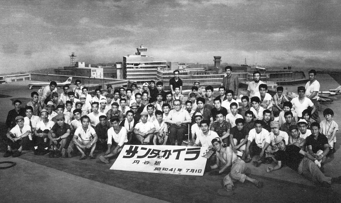 kantokuflash's tweet photo. 『フランケンシュタインの怪獣 サンダ対ガイラ』1966年

特撮班（円谷組）によるクランクアップ記念の集合写真。
広大な羽田空港の特撮セットが素晴らしい。
手作りの特撮シーンが実感できる写真だ。
中央の椅子に座る人物が円谷英二監督。
#昭和の特撮