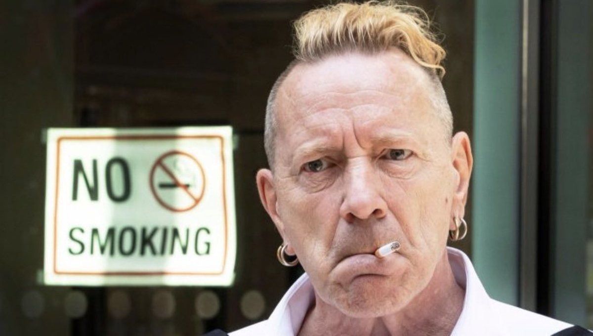 Visionaryvoid's tweet photo. British punk rock star John Lydon, aka ‘Johnny Rotten’ isn’t quite as wild in real life as his former on-stage persona would lead one to expect. In real life he’s been with the same woman for over forty years and he’s quite… behaved, off-stage. That does not stop the media from creating false and salacious stories, however. If a star’s personal life isn’t troubled they will MAKE it troubled by inventing issues

Lydon’s wife Nora was pictured once accompanied by a young dark fellow. Some unsavory tabloid wrote a story about how she was having “an affair with a young black lover” and cheating on Lydon. This was completely made up rubbish — John and Nora had a daughter who could not take care of her sons due to her drug addiction. They took the three boys into their home. The kids had a Jamaican father and a white mother.
Eventually the kids’ mother tragically died of cancer, at which point John and Nora adopted them officially and raised them full-time. Naturally, they grew very close. By the late 2010s the boys were grown up and a photo of one of them enjoying a perfectly innocent stroll with his own grandmother was made into something inappropriate just for ‘clicks’. A simple google search would have revealed the backstory but the paper couldn’t be arsed.
Tabloids can literally take something as harmless as a walk with your grandchild into a “secret affair”. Lydon called up the paper, had the story removed. I only learned about it when he later brought it up in an interview, but my goodness. These gutter publications are so vile.