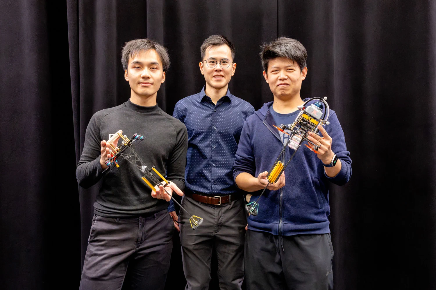 MIE PhD student Jeeraphat (Owen) Kledkruemas, Professor Pakpong Chirarattananon (MIE) and Song Li, a PhD student from the City University of Hong Kong on academic exchange at U of T Engineering, demonstrating two different versions of the ‘Hopcopter’, a one-legged, hopping robot with a range of applications.