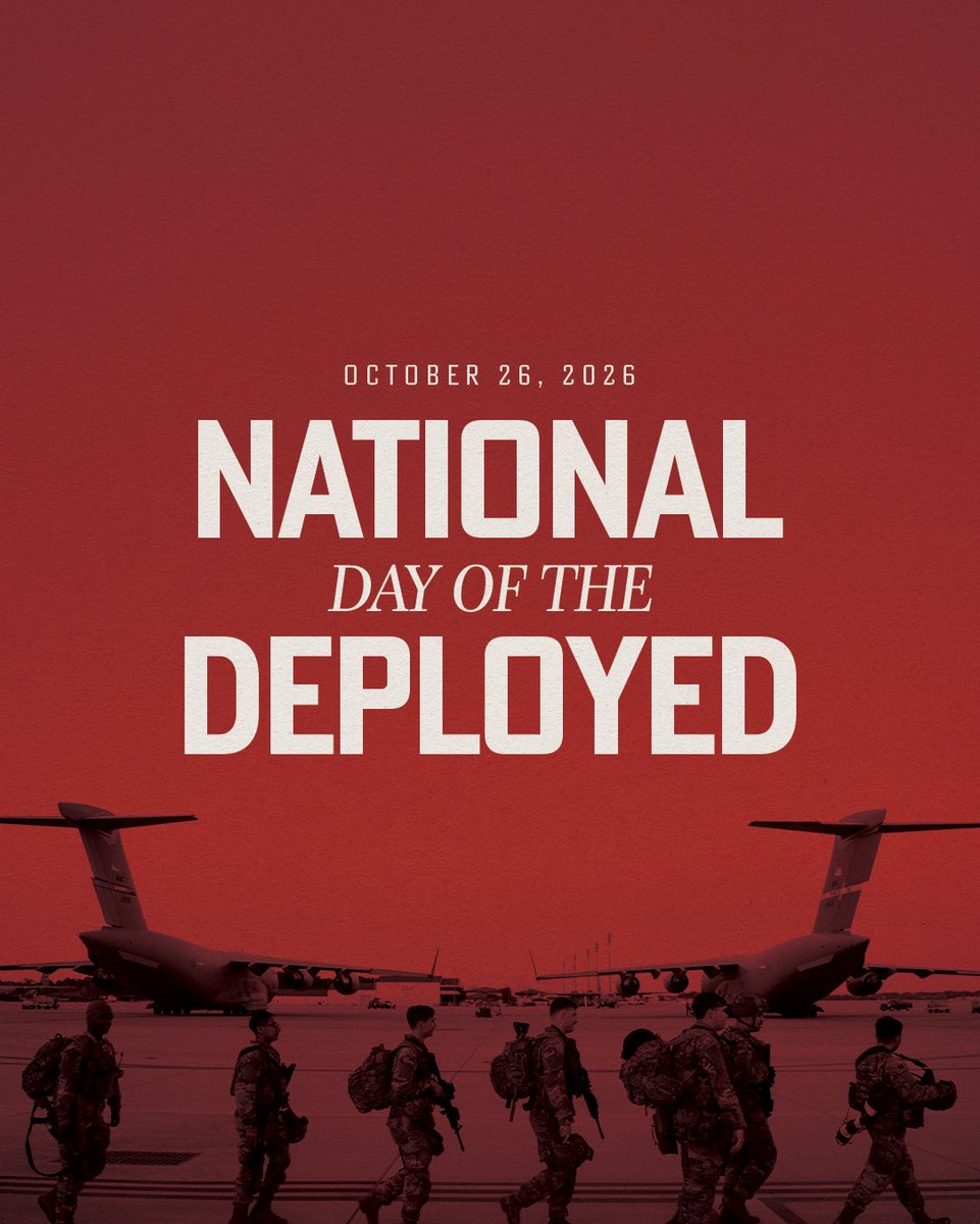 A red-toned poster commemorating a national day, with large centered lettering above a photograph of uniformed service members walking in front of two military transport aircraft. Text is present.