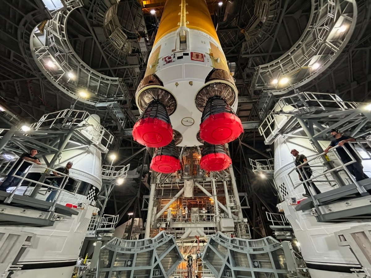AstroKomrade's tweet photo. ‘Taking Flight’ (nearly).  Our beautiful Artemis III Space Launch System (SLS) Core Stage left the surface of the earth (briefly) today as it ‘flew over the hump’ via a giant crane in the Vehicle Assembly Building to be mated between our 2 already assembled Solid Rocket Boosters on the Mobile Launcher.  Spectacular job by our SLS, Exploration Ground Systems,and  @NASAKennedy team! Go @NASAArtemis III!
