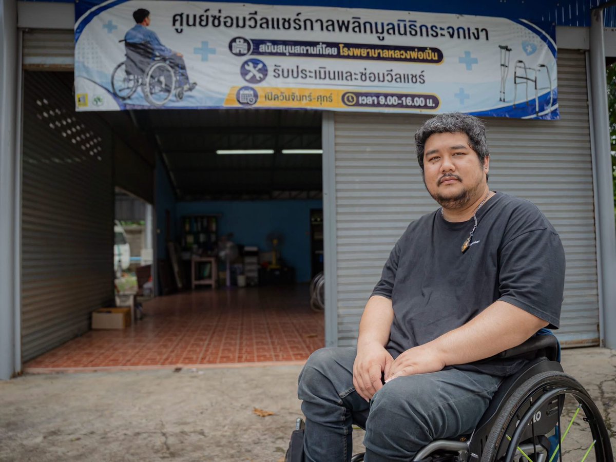 Mirror_org's tweet photo. “เราถูกลูกหลง โดนยิง...
.
“วันนั้นเป็นวันฮาโลวีน ( ปี 2554 ) จำได้ว่าแต่งหน้าผีไปเที่ยวผับกัน เรากำลังจะกลับแล้ว แต่เพื่อนไปมีเรื่อง กระโดดผลักอกฝ่ายตรงข้าม จังหวะมันเร็วมาก ตอนการ์ดเข้ามาห้าม เรายังยืนงงอยู่เลย
.
“ก็อาศัยช่วงชุลมุน เราพาเพื่อนหนีออกมา เพราะดูทรงมันเมามากแล้ว เลยกอดคอพาไปส่งขึ้นรถ แต่ระหว่างข้ามถนน ตอนข้ามไป กำลังจะสุดเลน กำลังจะถึงรถ เราได้ยินเสียงปืนดังขึ้นสองนัด
.
“เราไม่รู้สึกตัวไปประมาณสองสามวัน หลับ ๆ ตื่น ๆ  จนผ่านไปสักประมาณหนึ่งสัปดาห์ พออาการเริ่มดีขึ้น เริ่มมีสติตอบสนอง หมอก็เดินมาคุยกับแม่ที่ปลายเตียง หมอพูดว่า ‘ลูกจะพิการไปตลอดชีวิตนะ...’
.
“เราทำกายภาพอยู่ประมาณสองปี รักษาทุกวิธี ไปมาหมด แต่มันยังเหมือนเดิม เลยคิดว่าไม่หายแล้ว เราจะเป็นอย่างนี้ ก็เลยไม่ได้ไปหาวิธีรักษาอีก ใช้ชีวิตอยู่แต่ในบ้าน กินข้าว อาบน้ำ เล่นเกมไปวัน ๆ
.
“จนวันหนึ่ง เราได้รู้จักกับพวกพี่จากศูนย์การดำรงชีวิตอิสระของคนพิการ เขาชวนเราออกจากบ้าน ซึ่งช่วงแรกเราไม่อยากออก ไม่รู้จะออกไปทำไม ด้วยความที่ยังเด็ก อยู่บ้านสบายกว่า ดูโทรทัศน์ กินข้าว ขึ้นเตียงนอนเล่นโทรศัพท์ มันก็สะดวกเราแล้ว แต่เหมือนตัดความรำคาญ ในที่สุดเลยออกไป
.
“พอตัดสินใจออกไป เราก็ได้เจอกับพี่คนพิการหลาย ๆ คน ตอนนั้นสนใจว่า พวกพี่เขาใช้ชีวิตกันยังไง บางคนขับรถยนต์เองได้ ทั้งที่เขาพิการตั้งแต่คอ มันน่าสนใจมาก เราก็เลยออกมาเรื่อย ๆ เข้าประชุม ทำกิจกรรม แล้วช่วงปี 56-57 เราก็มีโอกาสเป็นอาสาสมัครในองค์กร จากนั้นก็ได้ทำงานที่นั่น
.
“พี่ ๆ พาเราไปลงพื้นที่ตามบ้านคนพิการ พาไปรู้จักเพื่อนคนพิการมากขึ้น ซึ่งเราได้เห็นว่า การพูดคุย ให้คำปรึกษา มันทำให้เพื่อนคนพิการเปลี่ยนแปลงตัวเองได้ ทำให้เขาออกมาใช้ชีวิตได้
.
“เราว่าการใช้ชีวิตในบ้านมันมีคุณค่า แต่การที่คนพิการได้กลับเข้าสู่สังคม ได้มีงานทำอีกครั้ง มันก็เป็นคุณค่าอีกแบบหนึ่ง
.
“เราทำงานอยู่ที่นั่นหลายปี กระทั่งหลังโควิด สมาชิกทยอยแยกย้ายกันไป พี่หัวหน้าศูนย์ ก็ย้ายมาเป็นหัวหน้าโครงการกาลพลิก มูลนิธิกระจกเงา และด้วยความที่เรายังอยากทำงานช่วยเหลือเพื่อนคนพิการ เลยมาเข้าร่วม
.
“ซึ่งพอเลือกทำต่อ เราก็มองหาแนวทางใหม่ ๆ  โดยเล็งเห็นว่า เวลาวีลแชร์ของคนพิการมีปัญหา เรามักจะหาศูนย์ซ่อมยาก เพราะโรงพยาบาลส่วนใหญ่ไม่รับซ่อม เขาจะรอครบสามปีถึงเปลี่ยนให้ทีเดียว ดังนั้น การเปิดศูนย์ซ่อมบำรุงรถวีลแชร์เลยน่าทำ
.
“เราตั้งใจเปิดกาลพลิกสาขา 2  ในพื้นที่นครปฐม เพราะตรงนี้เคยมีศูนย์ซ่อมวีลแชร์ เลยมาติดต่อโรงพยาบาลหลวงพ่อเปิ่น จนได้พื้นที่มาใช้
.
“เราอยากเห็นคนพิการเข้าถึงบริการซ่อมรถวีลแชร์ที่สะดวก เพราะเมื่อเราซ่อมให้เขาแล้ว เขาก็จะมีสุขภาพจิตดี วีลแชร์มันเป็นส่วนหนึ่งของร่างกายเราด้วย อย่างเช่นตัวเราเอง ถ้าวันนึงวีลแชร์พัง มันไปไหนไม่ได้ ก็รู้สึกแย่นะ 
.
“แต่ถ้าวีลแชร์ดี
.
“มันก็เหมือนเรามีขาที่ดี
.
“สามารถไปไหนมาไหนได้อิสระ...”
_______________
(ออม) รณภัฎ วงศ์ภา เจ้าหน้าที่โครงการกาลพลิก สาขานครปฐม
_______________

แม้วันนี้ ศูนย์ซ่อมวีลแชร์จะเปิดให้บริการแล้ว แต่เรายังคงต้องการ อุปกรณ์เครื่องมือช่าง อะไหล่สำรอง ซึ่งคือของจำเป็น อีกจำนวนมาก เพื่อใช้ซ่อมวีลแชร์ชำรุด ก่อนส่งคืนเพื่อนคนพิการ
.
ทุกการบริจาคอะไหล่ เครื่องมือ หรือการสมทบทุน จึงเป็นอีกแรงสนับสนุนสำคัญ ที่จะทำให้คนพิการ สามารถออกไปใช้ชีวิต
.
ให้โอกาสคนพิการออกมาใช้ชีวิต โดยการสนับสนุนศูนย์ซ่อมวีลแชร์ ได้ที่
โครงการกาลพลิก มูลนิธิกระจกเงา
เลขที่ 202-272892-9 (ธนาคารไทยพาณิชย์)

#โครงการกาลพลิก #มูลนิธิกระจกเงา