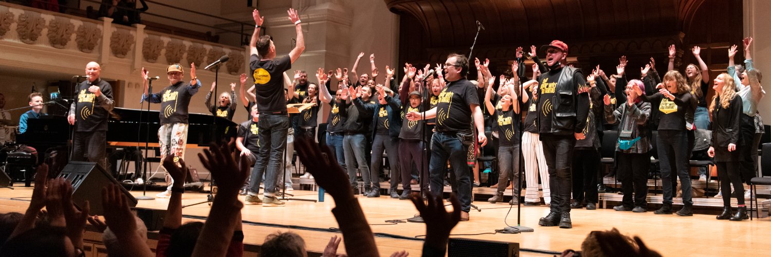Choir with No Name banner
