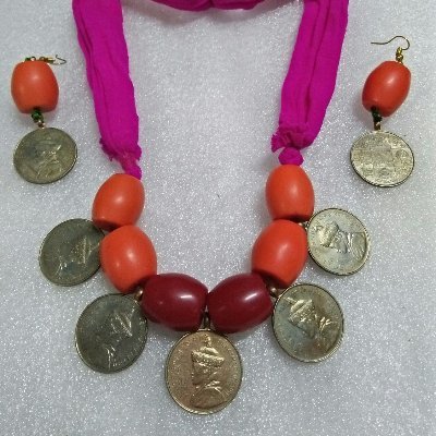 Numismatist and maker of coin jewelry from Bhutan coins with Buddhist 8 auspicious symbols for good luck