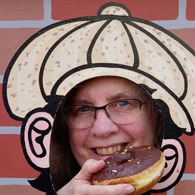 I write the Deputy Donut Mysteries--cops, coffee, crime, and donuts. As @JanetBolin, I wrote the Threadville Mysteries--murder, mayhem, and needlecraft.