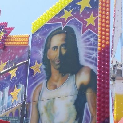 A Nick Cage mural at a traveling carnival.