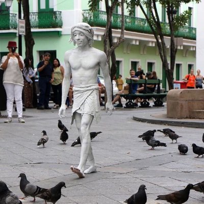 Soy una estatua viviente camuflajeada con cuatro estatuas que datan de hace 164 años. Me verán en la Plaza de Armas de Viejo San Juan, Puerto Rico.