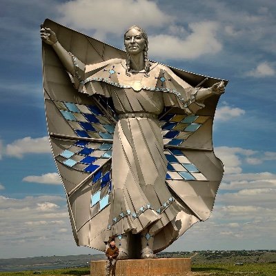 Dignity of Earth and Sky is a soaring sculpture of a native woman standing high on a bluff above the Missouri River.
Dignity honors the Native Nations