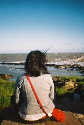 recostada em cadeira de plástico.